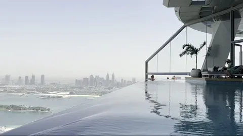 Side view of Aura Skypool with skyline, glass corner, and palm